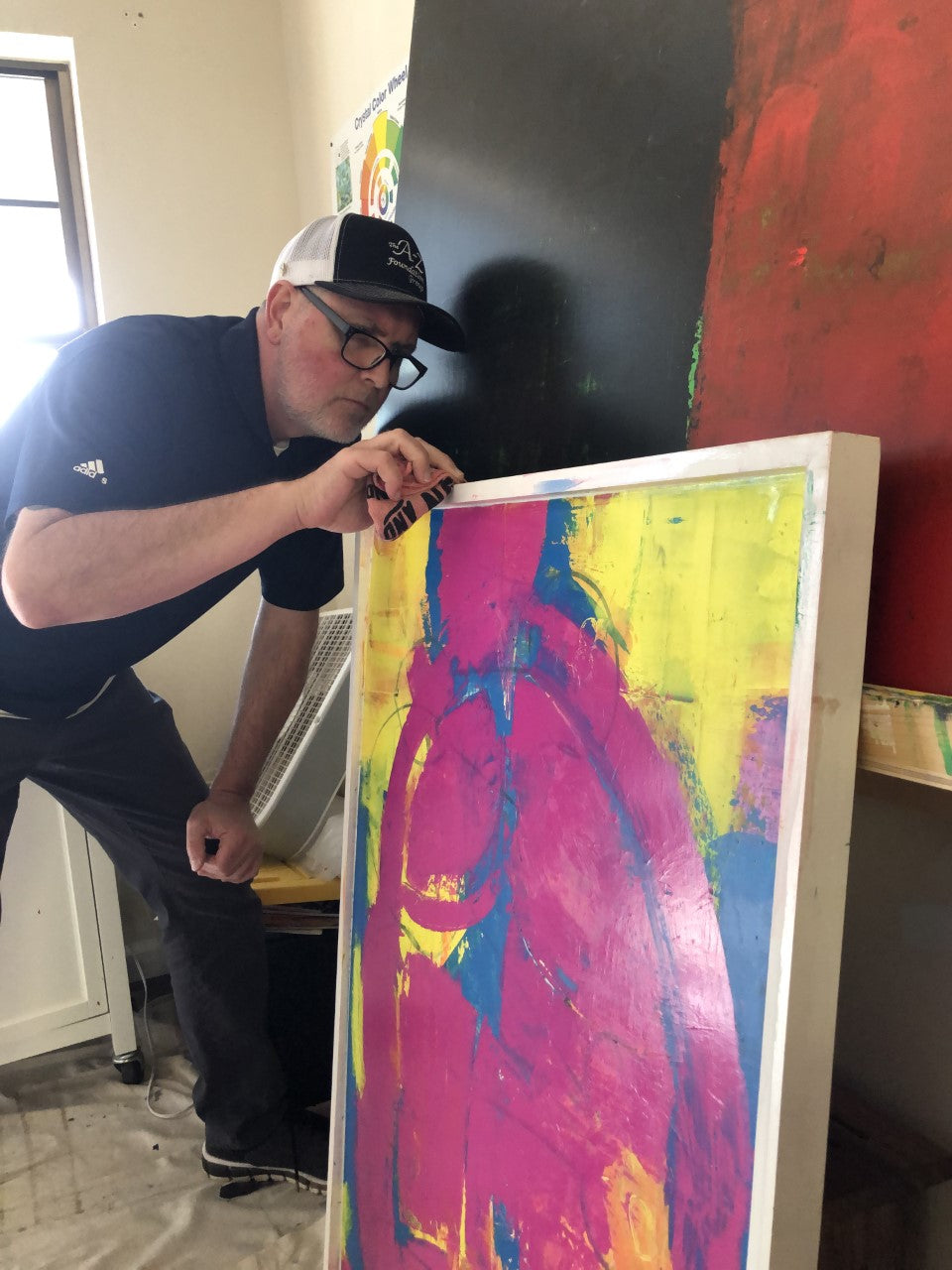 Artist Arron J McGuire working on framed wall art in his studio